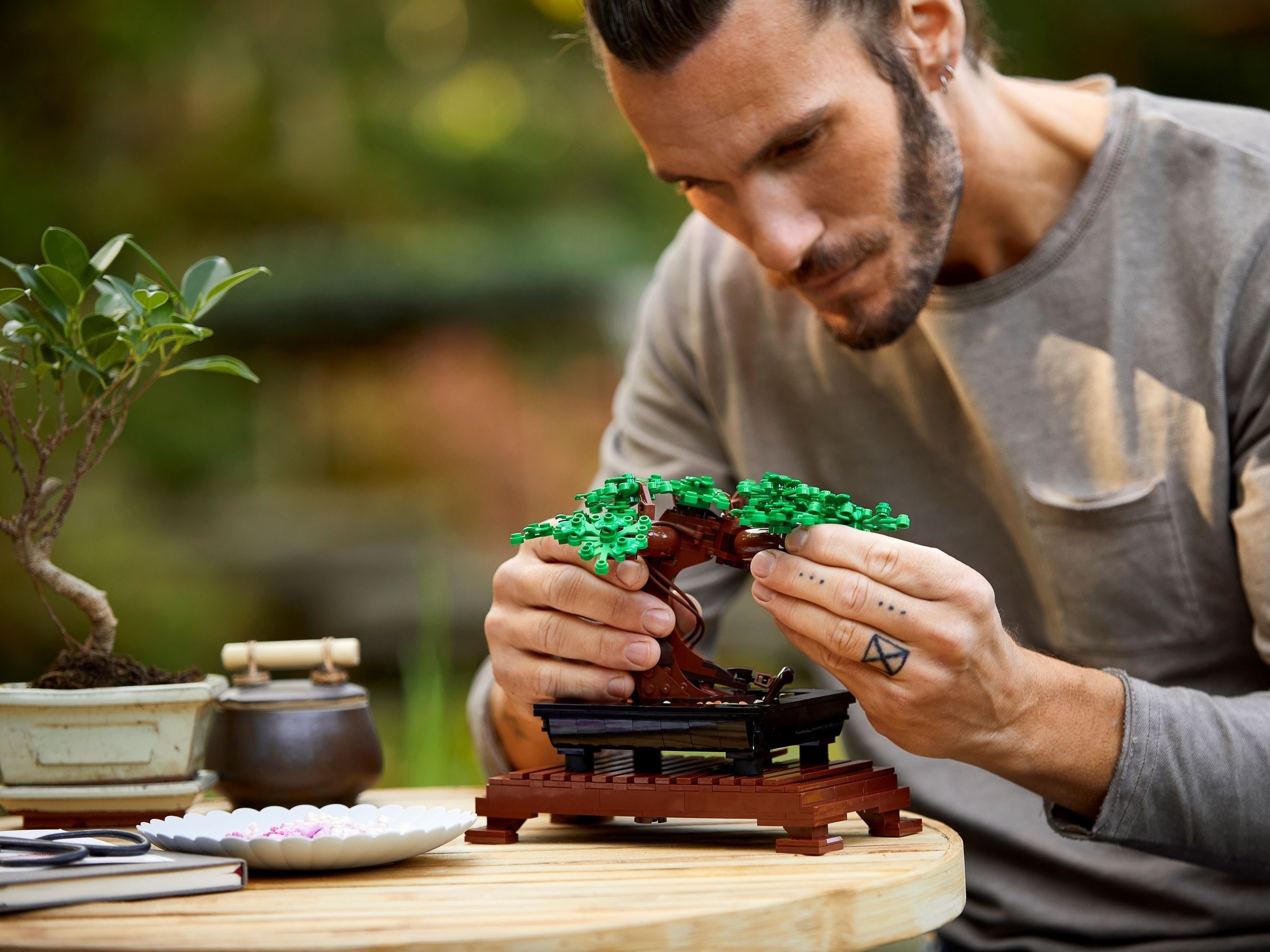 LEGO Botanicals Bonsaï 10281 - montage en cours avec les mains qui construisent le tronc