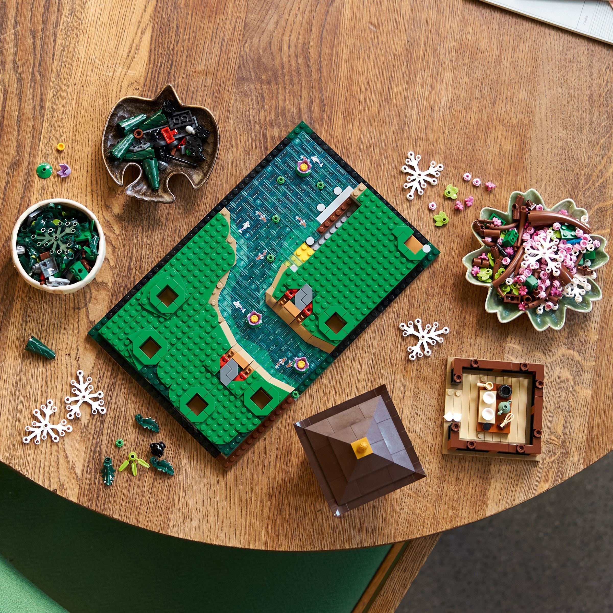 LEGO Icons Le Jardin Paisible 10315 - vue plongeante du montage avec pièces étalées